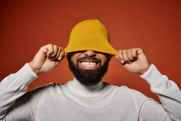 Bell'uomo afroamericano in abiti alla moda sorridente su uno sfondo vibrante. — Foto stock
