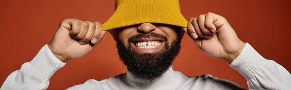 Handsome African American man wearing a fashionable hat on a colorful background. — Stock Photo