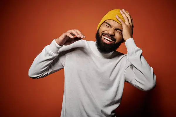 Homme élégant avec barbe portant un chapeau jaune sur fond coloré. — Photo de stock