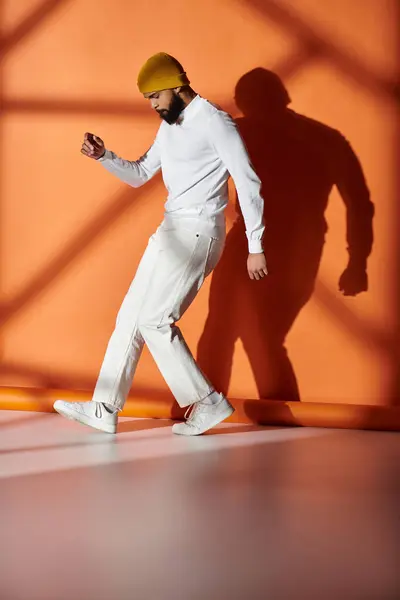 An elegant African American man walking confidently in a striking white suit and vibrant yellow helmet. — Stock Photo