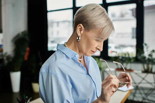 Middle-aged businesswoman with short hair in an office setting during menopause. — Stock Photo