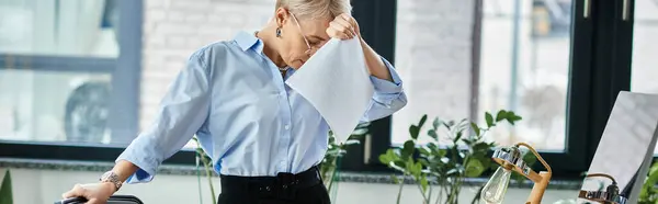 Middle-aged businesswoman in blue shirt and black pants feeling unwell during menopause — Stock Photo
