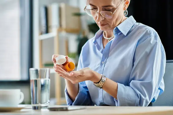 Femme d'affaires d'âge moyen aux cheveux courts prenant la pilule pendant la ménopause — Photo de stock