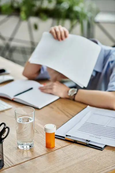A middle-aged businesswoman with short hair sits at a table, surrounded by papers, deep in thought during menopause. — Stock Photo