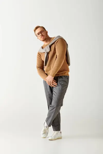 A handsome man in stylish attire posing actively with hands in pockets. — Stock Photo