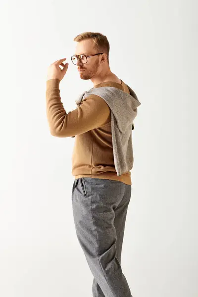 Handsome man in glasses and sweater standing confidently. — Stock Photo