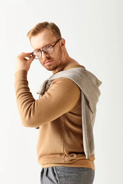 Handsome man posing confidently in stylish glasses and sweater. — Stock Photo