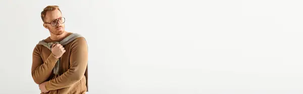Handsome man in sweater striking a pose against white backdrop. — Stock Photo