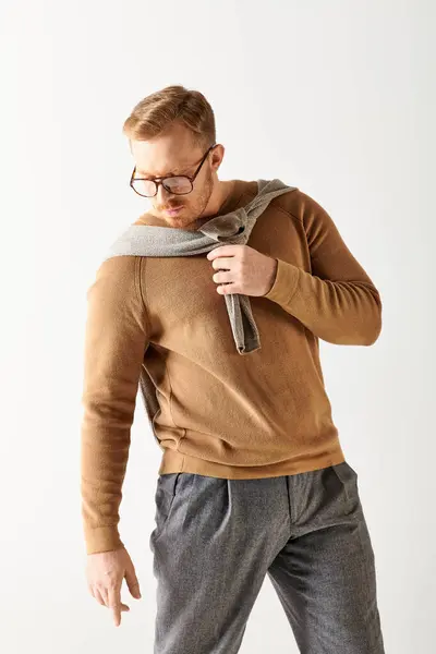 A stylish man wearing glasses and a sweater poses confidently. — Stock Photo