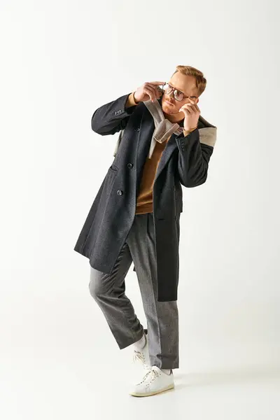 A man in a black coat and glasses posing. — Stock Photo
