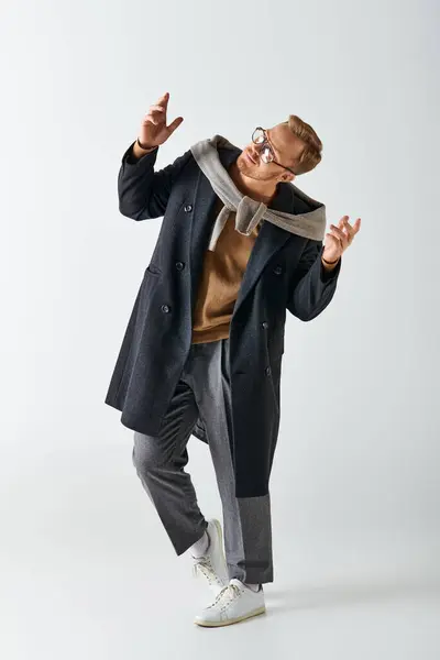 Ein stilvoller Mann in Mantel und Brille tanzt energisch. — Stockfoto