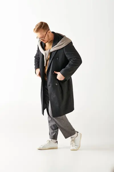 A stylish, enigmatic man strides confidently in a black coat. — Stock Photo