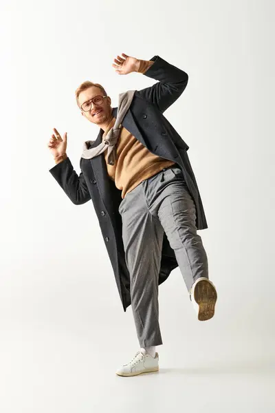 A stylish man in a trench coat gracefully dances with flair. — Stock Photo