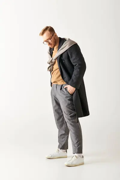 A man in glasses and a coat stands confidently. — Stock Photo