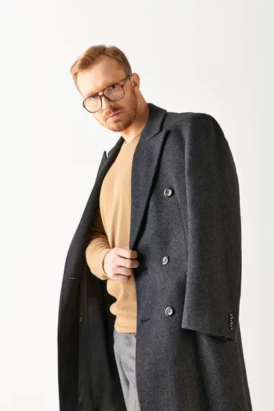 A stylish man in black coat and glasses strikes a dynamic pose. — Stock Photo