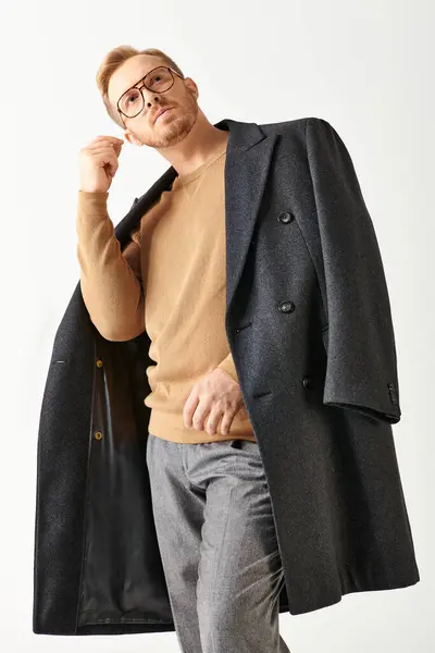 Ein Mann mit Brille und Mantel posiert selbstbewusst für ein Porträt. — Stockfoto