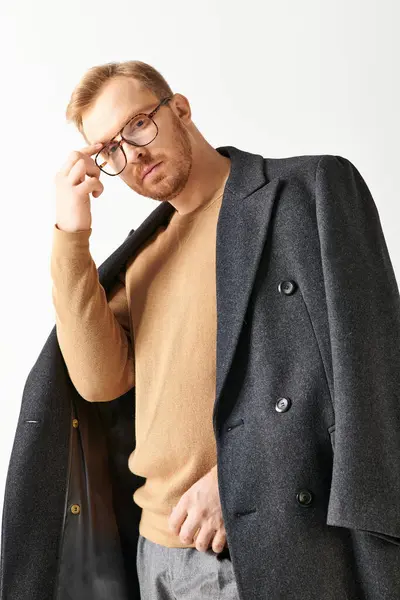 A stylish man in a coat and glasses with poise. — Stock Photo