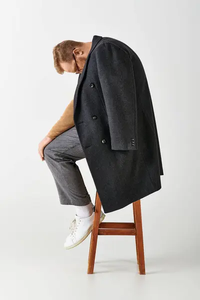 Stilvoller Mann sitzt selbstbewusst auf einem Holzstuhl. — Stock Photo