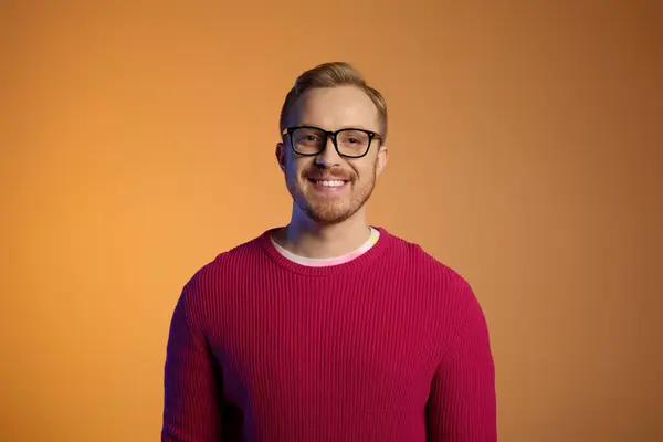 Handsome man in glasses and red sweater strikes a stylish pose. — Stock Photo