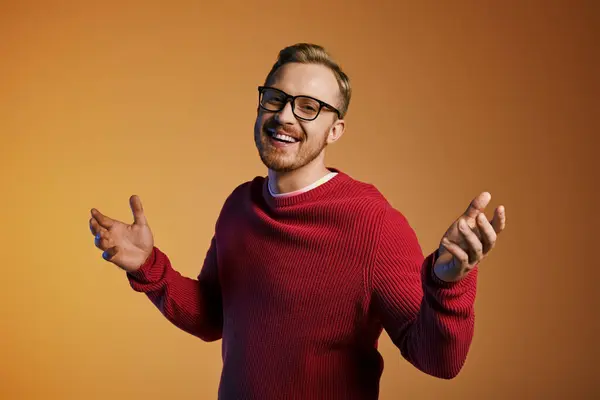 Handsome man wearing glasses and red sweater posing confidently. — Stock Photo