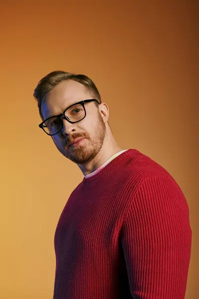 Uomo elegante in occhiali e maglione rosso posa con fiducia. — Foto stock