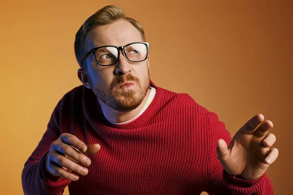 A man posing confidently in a red sweater and glasses. — Stock Photo