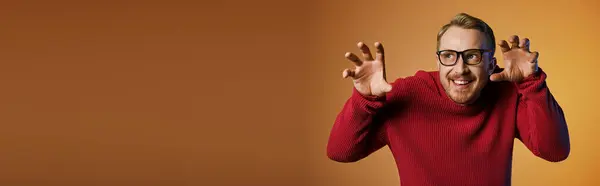 Handsome man in stylish red sweater making a quirky facial expression. — Stock Photo