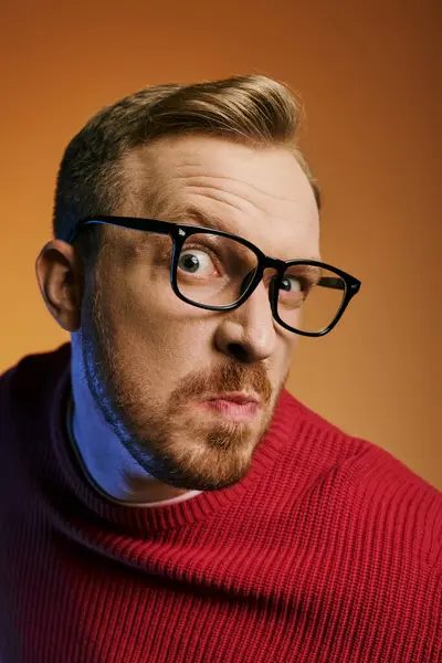 A stylish man in red sweater and eyeglasses striking a pose. — Stock Photo