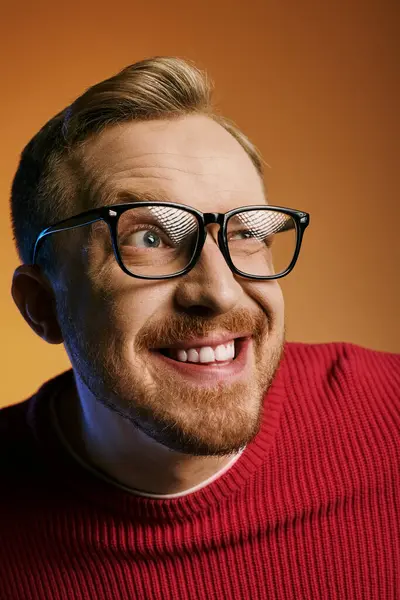 A handsome man in glasses and a red sweater strikes a dynamic pose. — Stock Photo