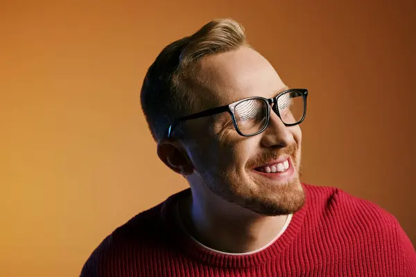 A dapper man in glasses and a red sweater, striking a thoughtful pose. — Stock Photo