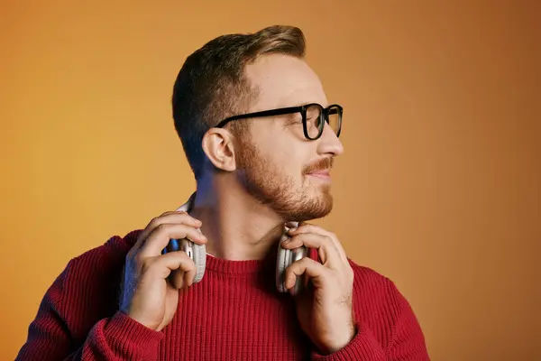 Handsome man with glasses posing confidently in a red sweater. — Stock Photo