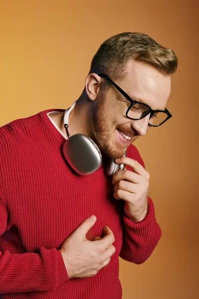 Handsome man in red sweater with headphones. — Stock Photo