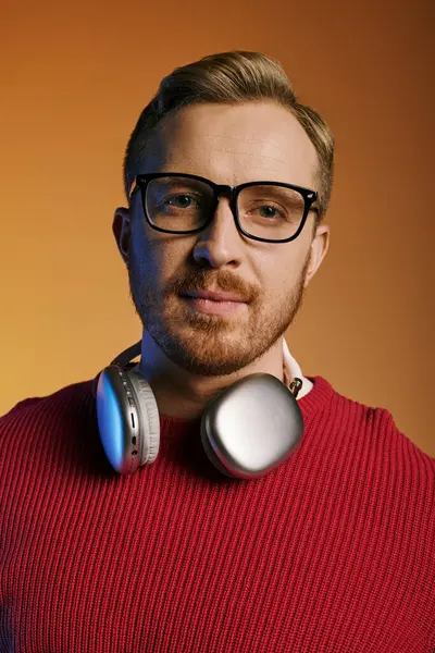 Handsome man posing in a trendy red sweater and glasses. — Stock Photo