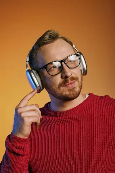 Ein bärtiger Mann mit Brille hört aufmerksam zu, Kopfhörer aufgesetzt.. — Stockfoto