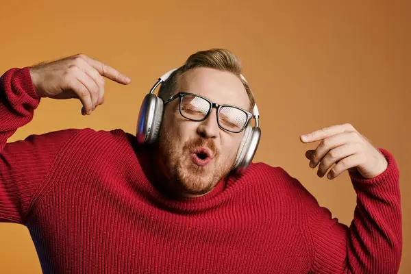 Стильний чоловік в окулярах і навушниках робить смішне обличчя. — стокове фото