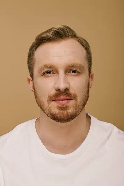 A stylish man with a beard poses in a white shirt. — Stock Photo