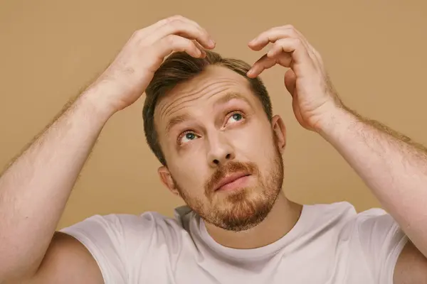 Um homem elegante segurando seu cabelo na frente de sua cabeça. — Fotografia de Stock