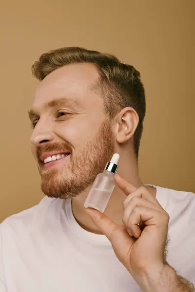 A man in casual attire holding a serum in his right hand. — Stock Photo