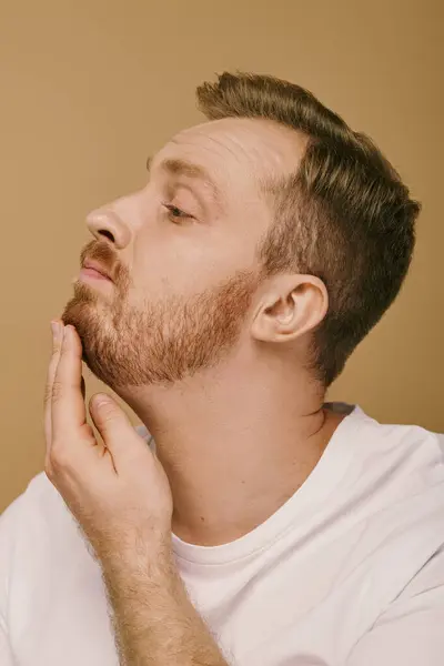 A stylish man with a beard and white shirt strikes a confident pose. — Stock Photo