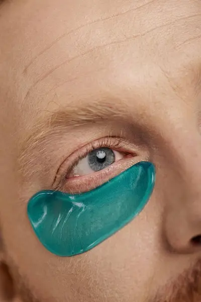 A handsome man in casual attire sporting striking green eye patches on his face. — Stock Photo