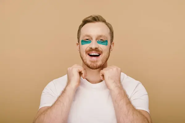 Bearded man with blue eye patches focused on his skincare routine. — Stock Photo