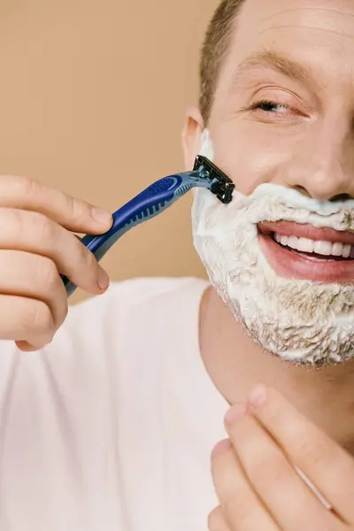 Un uomo in abbigliamento casual radersi il viso con precisione. — Foto stock