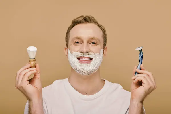 A stylish man with a goatee carefully applies shaving cream with a brush. — Stock Photo