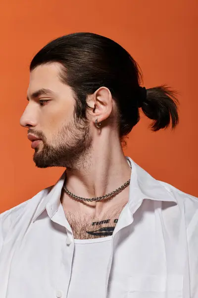 Bello uomo caucasico con abbigliamento alla moda e una coda di cavallo. — Foto stock