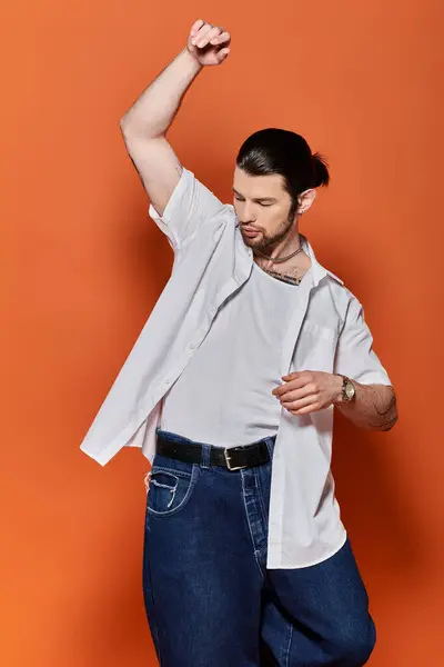 Stylish Caucasian man strikes a pose in white shirt and jeans. — Stock Photo