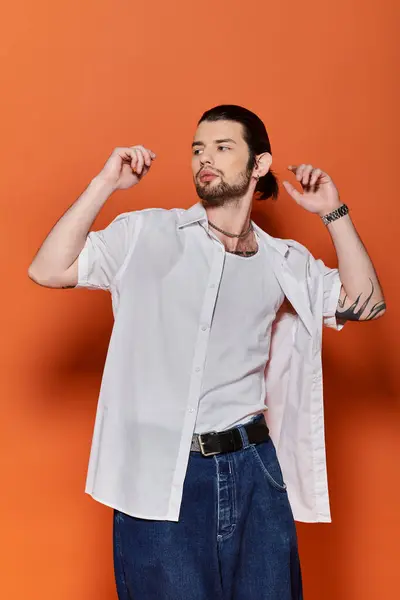 Caucasian man exudes charm in a white shirt and blue jeans. — Stock Photo