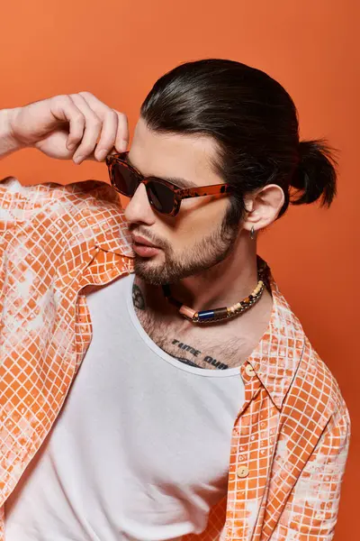 A fashionable Caucasian man sporting a ponytail and sunglasses. — Stock Photo
