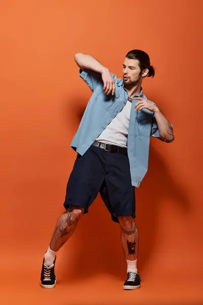 Caucasian man in trendy blue shirt and shorts posing confidently. — Stock Photo