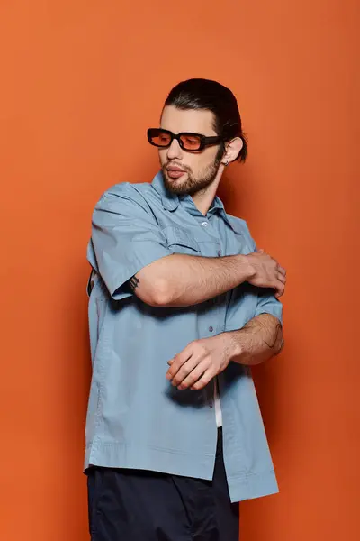 A handsome Caucasian man wearing sunglasses and a blue shirt. — Stock Photo