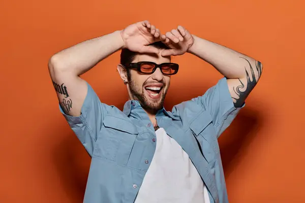 Handsome Caucasian man in trendy blue shirt and sunglasses. — Stock Photo